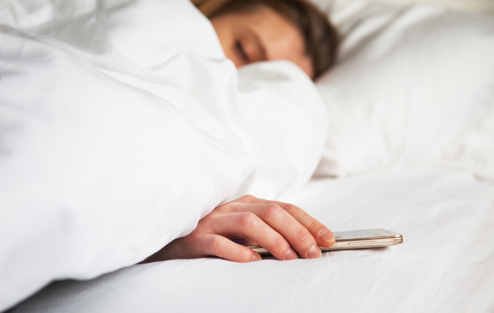 women is woken up by smartphone ringing